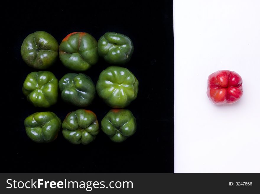 Red and green bell peppers on white and black background. Red and green bell peppers on white and black background
