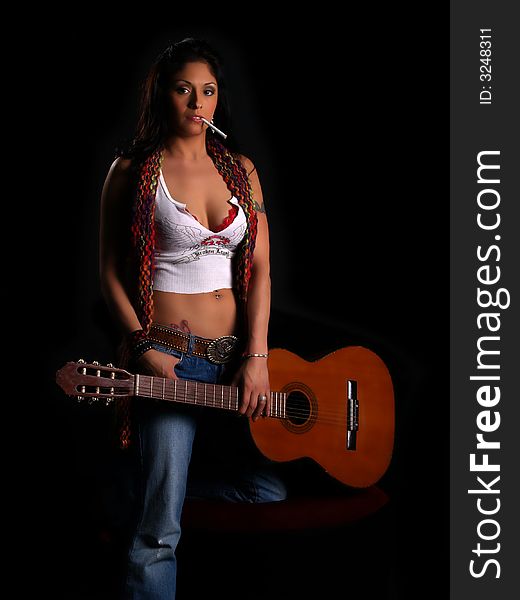 Beautiful rock chick with an acoustic guitar and a cigarette in her mouth