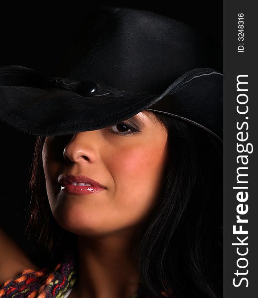 Beautiful latino with a hat posing over black. Beautiful latino with a hat posing over black