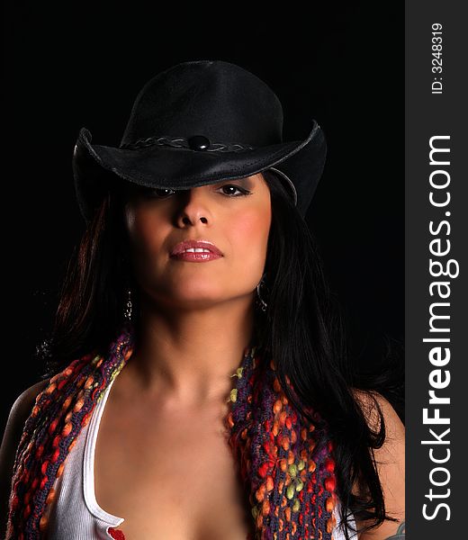 Beautiful latino with a hat posing over black. Beautiful latino with a hat posing over black