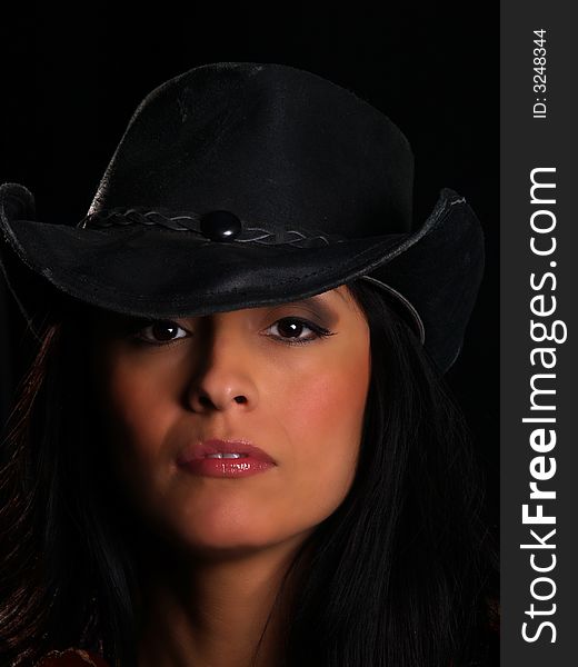 Beautiful latino with a hat posing over black. Beautiful latino with a hat posing over black