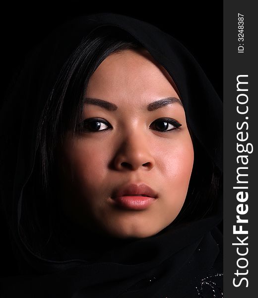 A Beautiful Asian girl over black with a balck scarf over her head