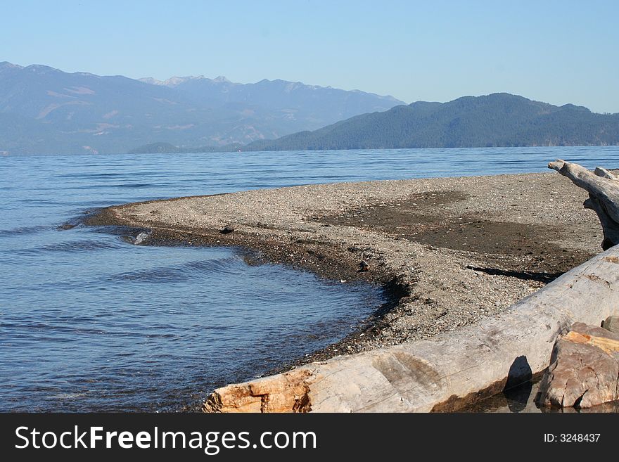 Water Sand Stump And Mountains