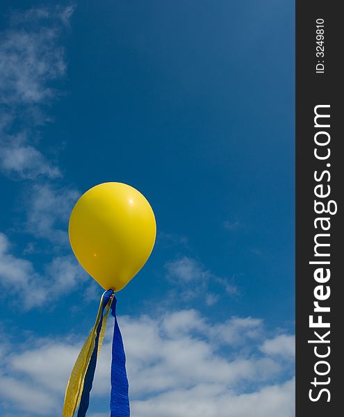 A yellow balloon on a blue sky