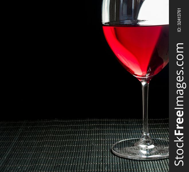 Wineglass with red wine, grey background