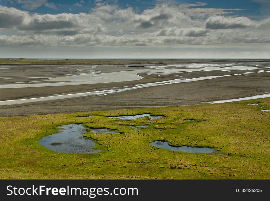 Little lake and the river delta on bright day in Iceland. Little lake and the river delta on bright day in Iceland