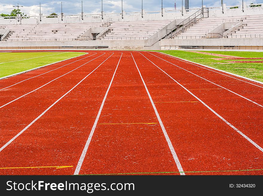 Blank orange track in the stadium (runway) on the side of football field