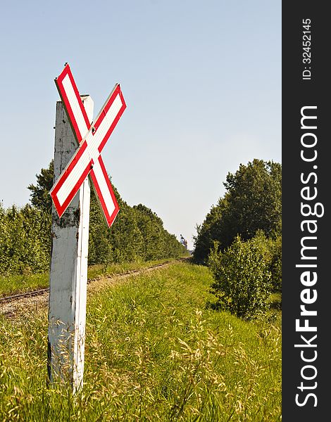 A white and red warning sign for trains crossing country road. A white and red warning sign for trains crossing country road.