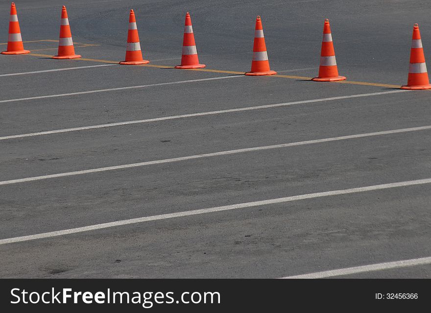 Orange traffic cones in order with white lines
