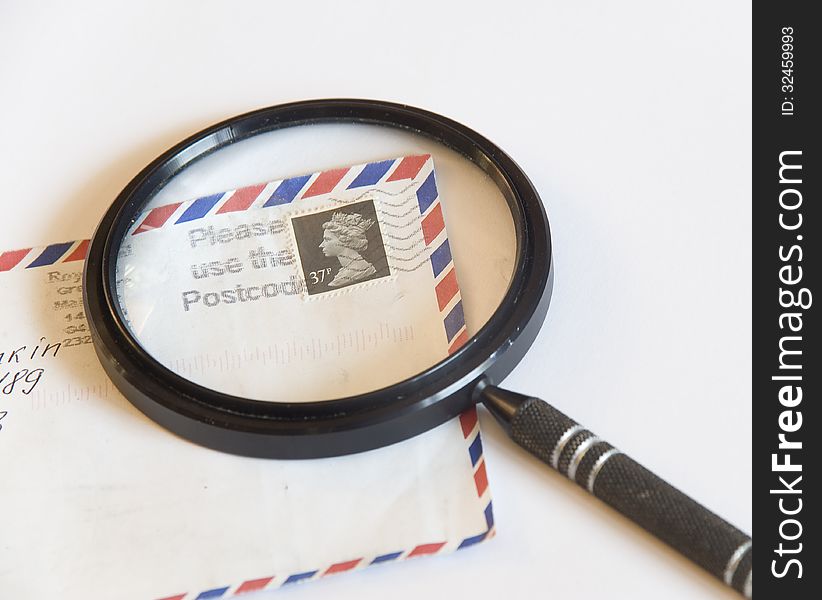Magnifying glass on an envelope with a postage stamp