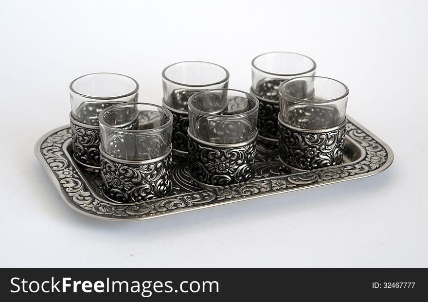 Old silver wine-glasses with pattern on a tray diagonal foreshortening