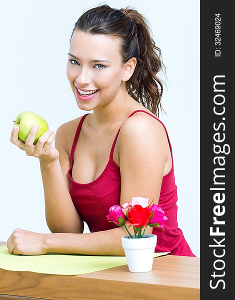 Pretty woman eating one green apple at home