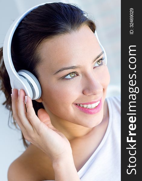 Pretty young woman listening music at home