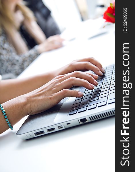 Woman hands typing on laptop at the office