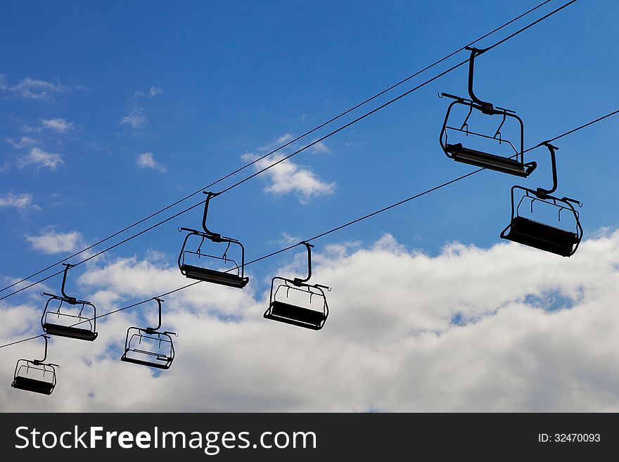 Chair lift, cableway on blue sky background