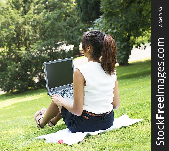 Woman working with computer in the park. Woman working with computer in the park.