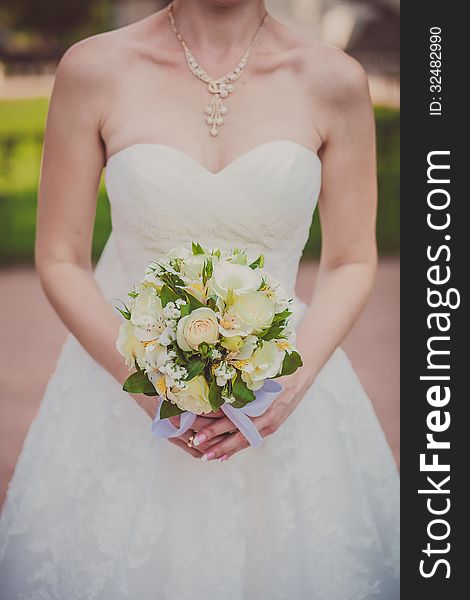 Bridal bouquet of flowers in hands of the bride