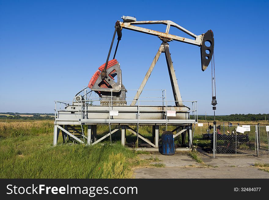 An oil pump jack on the field. An oil pump jack on the field.