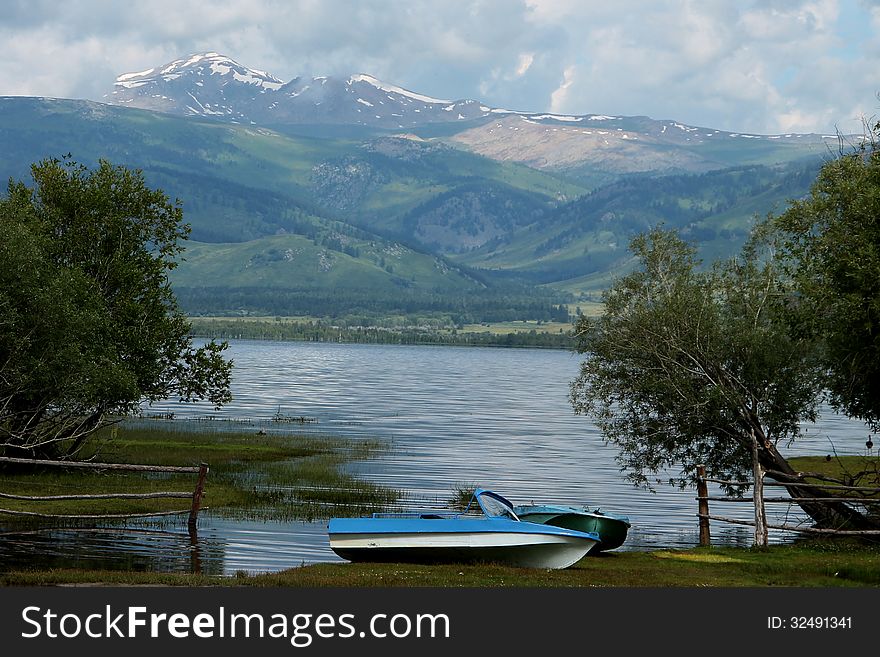 Markakol mountain lake with boat in beautiful natural landscape in Altai East Kazakhstan. Markakol mountain lake with boat in beautiful natural landscape in Altai East Kazakhstan