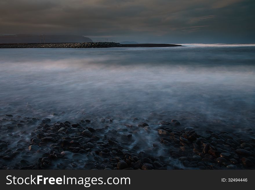 Seashore with pebbles. Photo was taken with long exposure in southern Iceland. Seashore with pebbles. Photo was taken with long exposure in southern Iceland