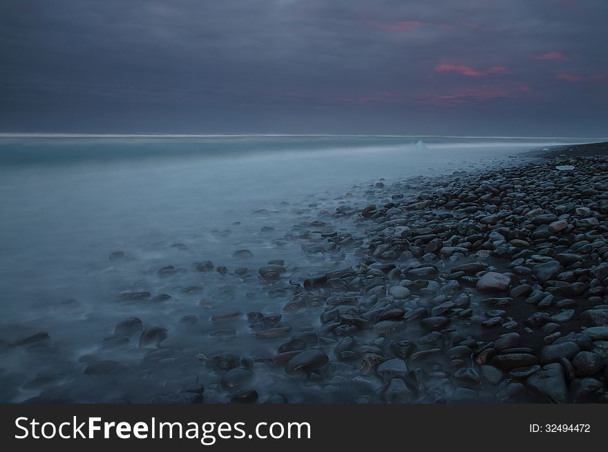 Seashore with pebbles. Photo was taken with long exposure in southern Iceland. Seashore with pebbles. Photo was taken with long exposure in southern Iceland