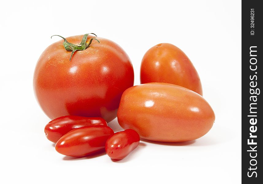 Group of three types and sizes of red tomatoes against a white background. Group of three types and sizes of red tomatoes against a white background