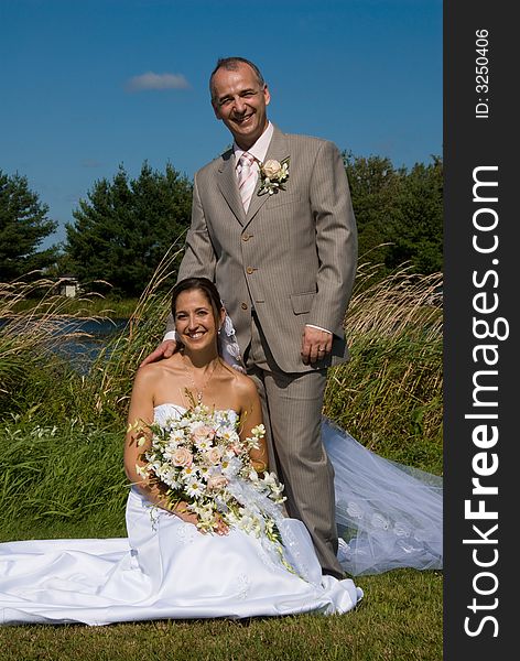 A just married man and woman by a lake. A just married man and woman by a lake