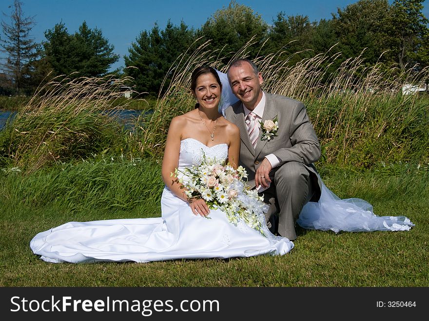 A just married man and woman by a lake. A just married man and woman by a lake