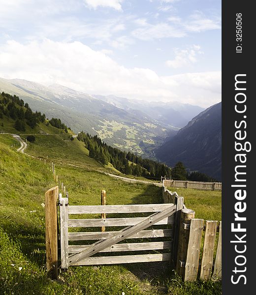 Samll wooden gate. In background view on austrian Alps. Samll wooden gate. In background view on austrian Alps.