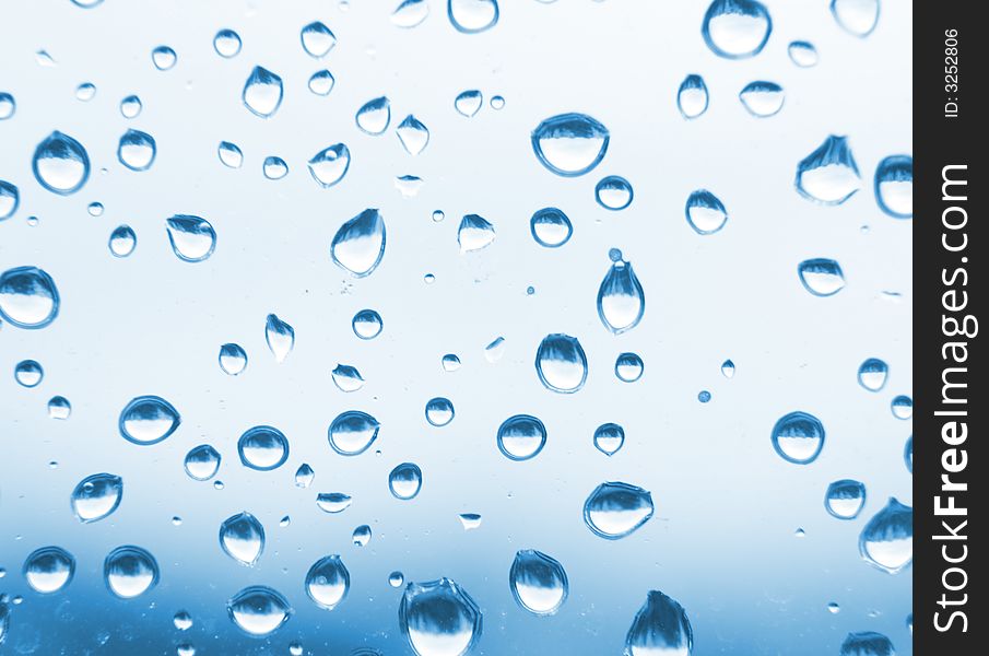 Water drops background in the blue color