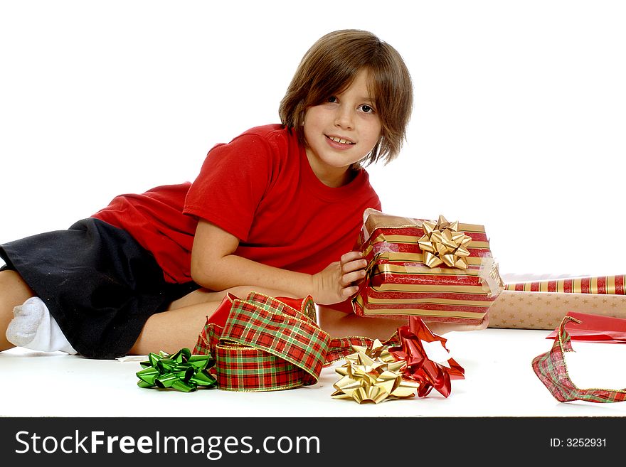 Young elementary girl displaying a gift she wrapped herself for Christmas giving. Young elementary girl displaying a gift she wrapped herself for Christmas giving.