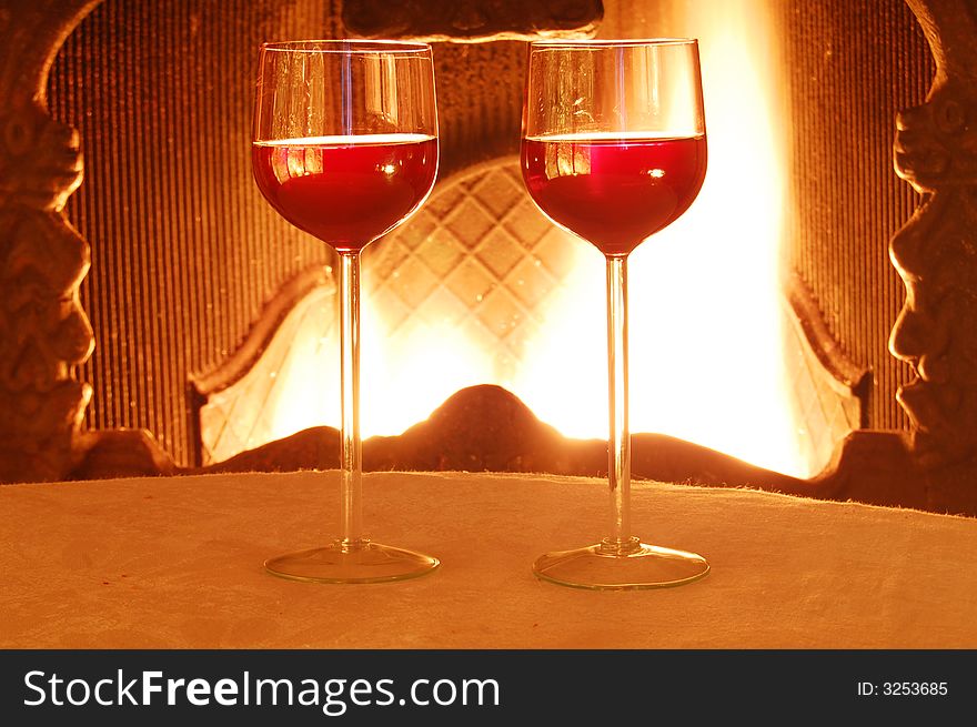 Two glass of wine against the fire background.