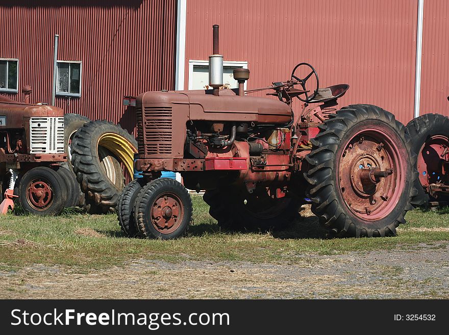Two Old red tractors with tires