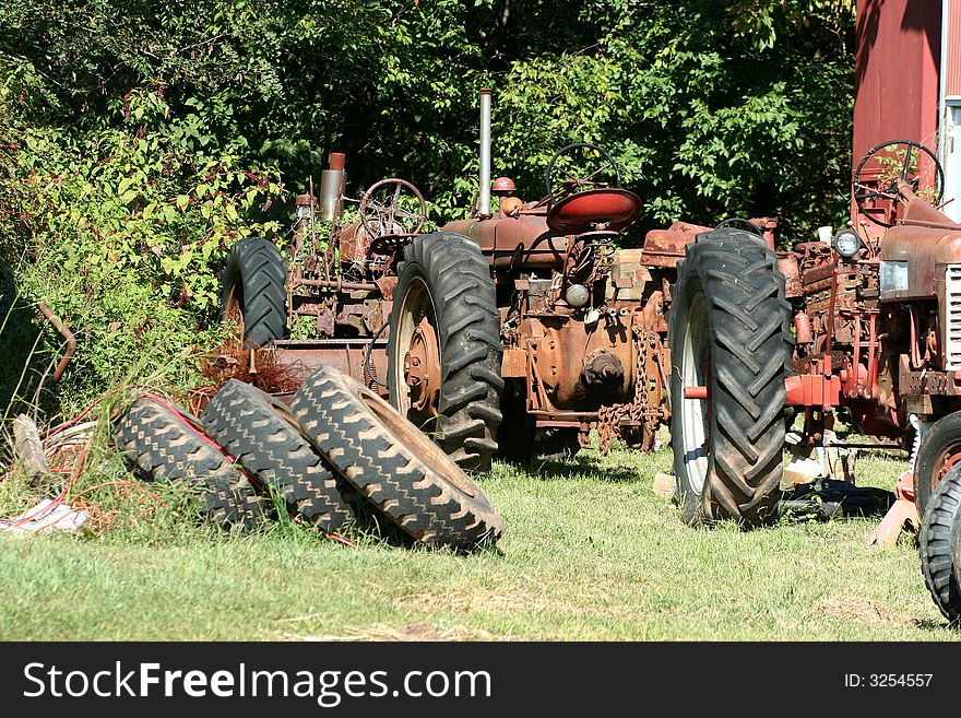 Two Old red tractors with tires