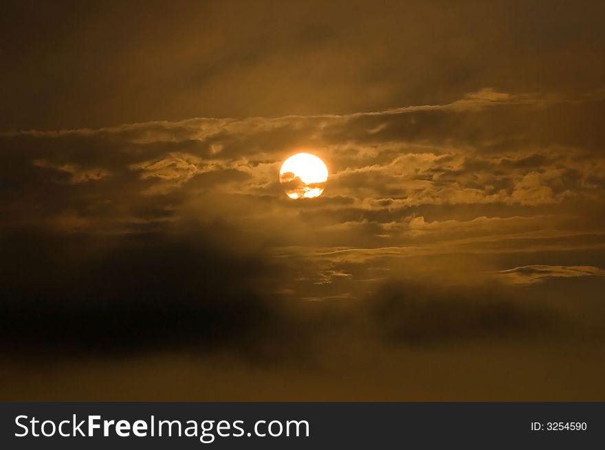 Sunset at the boat ramp off Mattapoisett Neck Road in Mattapoisett, MA, USA. The sun is visible on an orange/black background and foreground with clouds and room for text. Sunset at the boat ramp off Mattapoisett Neck Road in Mattapoisett, MA, USA. The sun is visible on an orange/black background and foreground with clouds and room for text.