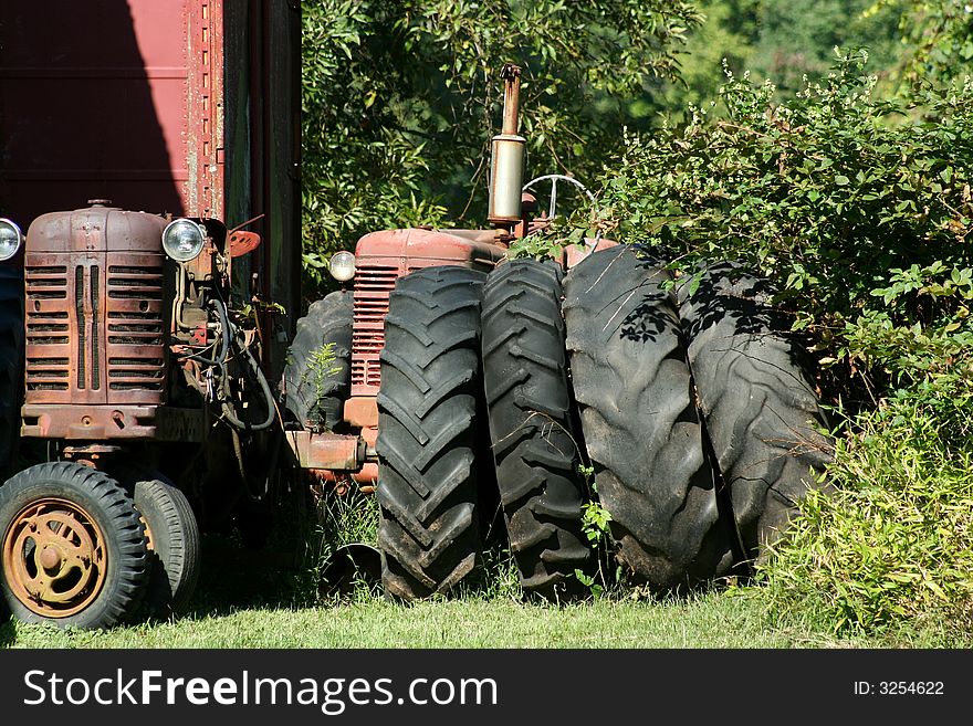 Two Old red tractors with tires