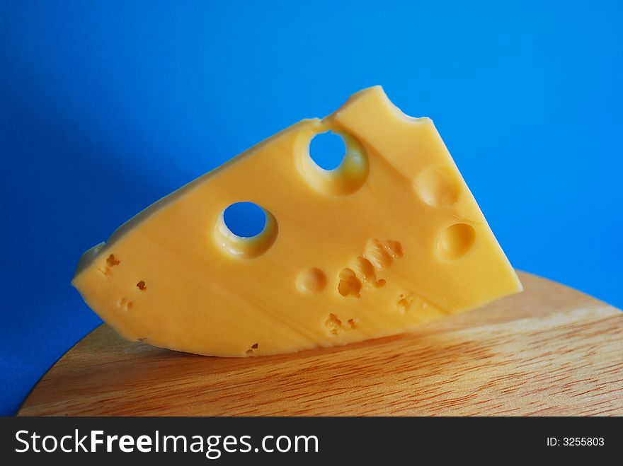 Piece of cheese on a blue background
