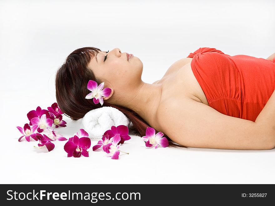 An asian women lying amongst flowers in a studio. An asian women lying amongst flowers in a studio