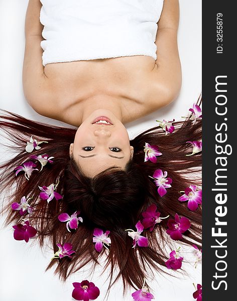 An asian women lying amongst flowers in a studio. An asian women lying amongst flowers in a studio