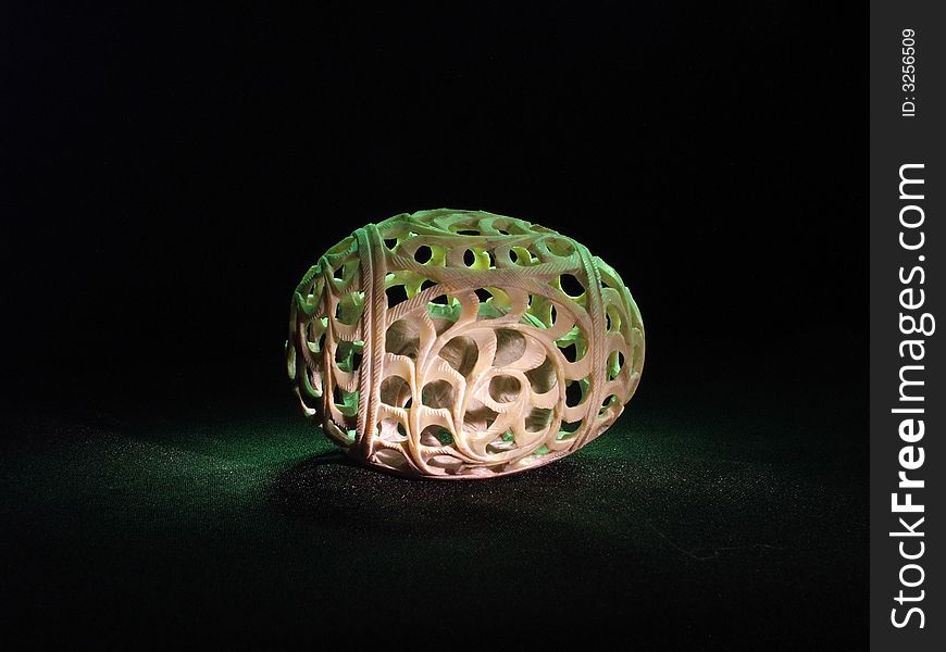 Carved openwork stone egg from India with illumination on black background. Carved openwork stone egg from India with illumination on black background