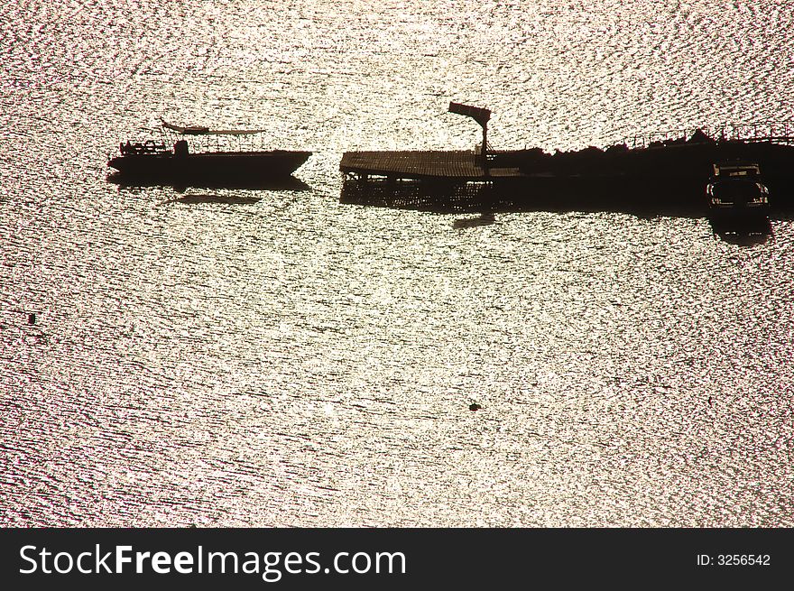 A small boat tied to the dock at sunrise. A small boat tied to the dock at sunrise