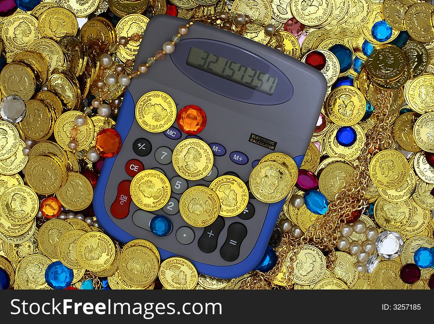 Vivid picture of a calculator in the midst of jewels and gold. Vivid picture of a calculator in the midst of jewels and gold.