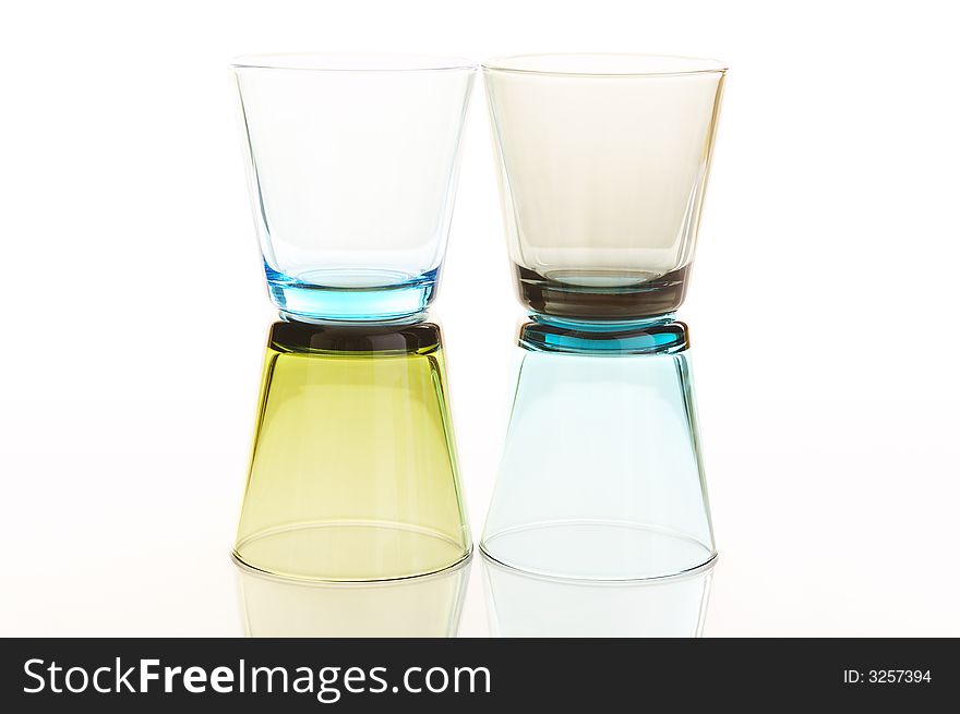 Colorful water glasses stacked over a white reflective background