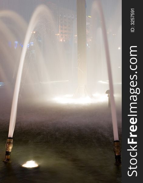 An impressive view of a water fountain at night at its full height. An impressive view of a water fountain at night at its full height