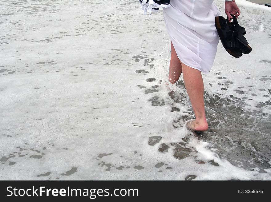 A woman strolling through the wave on the beach. A woman strolling through the wave on the beach