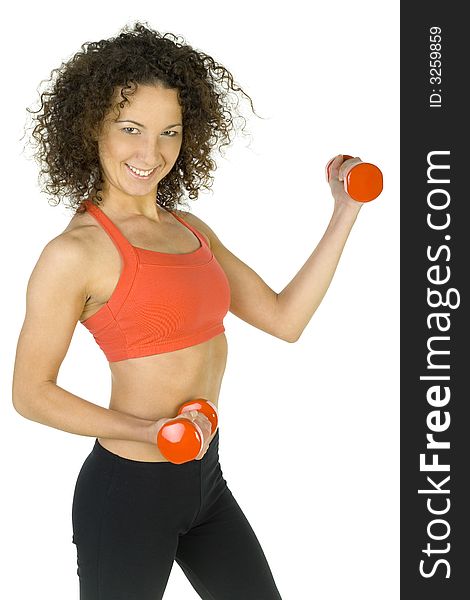 Young, beautiful woman working out with dumbbells. Smiling and looking at camera. White background, side view. Young, beautiful woman working out with dumbbells. Smiling and looking at camera. White background, side view