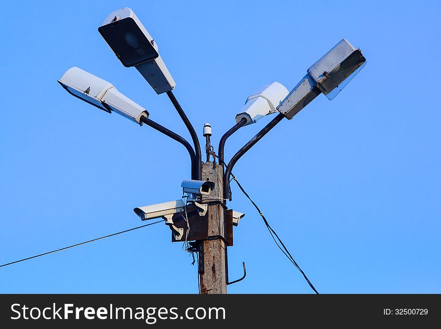 A Bunch of Security Cameras and lamps with Blue Sky