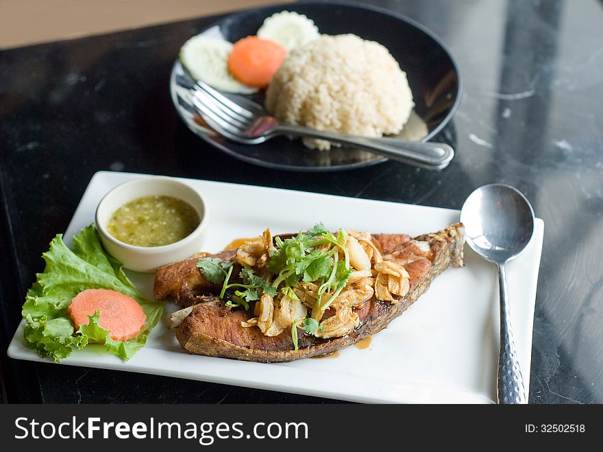 Piece of deep fried fish serve with spicy sauce and rice. Piece of deep fried fish serve with spicy sauce and rice