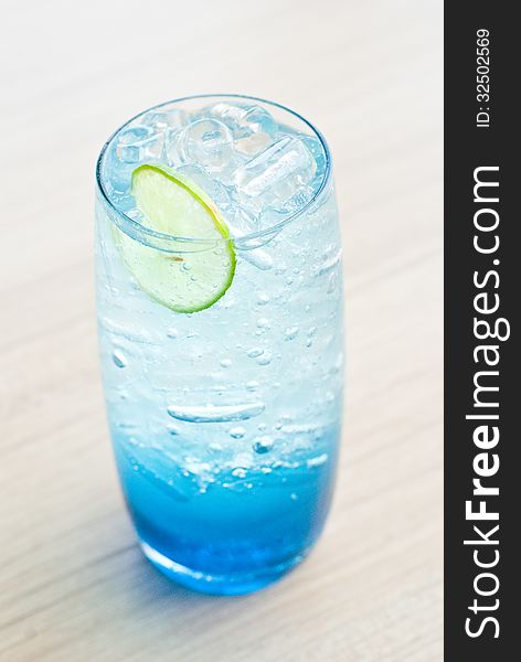 Glass of ice lime soda with blue syrup