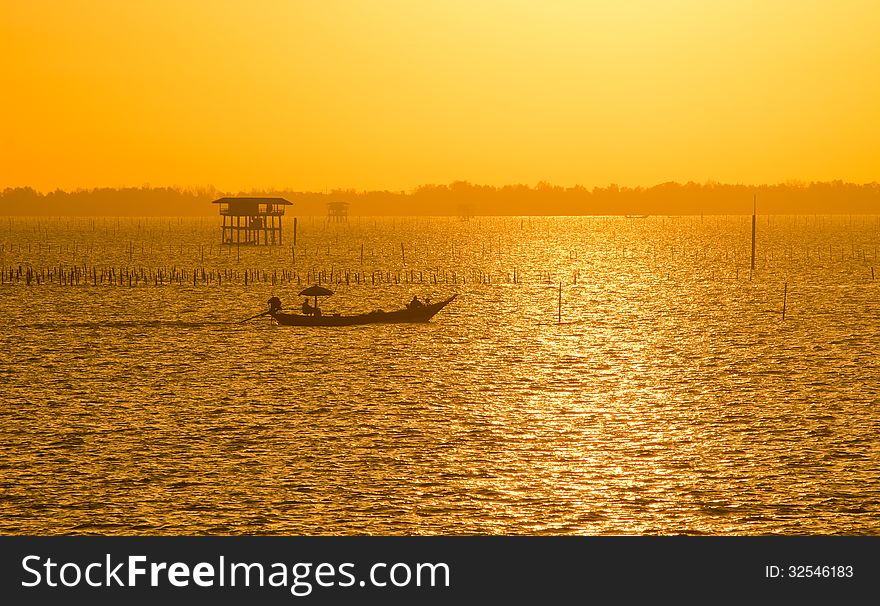 Fisherman boat with golden sunrise on the sea
